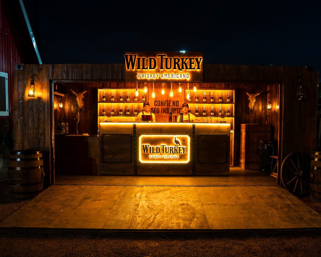 Bar Wild Turkey no Rancho 101 com identidade visual da marca e espaço para consumo e interação.